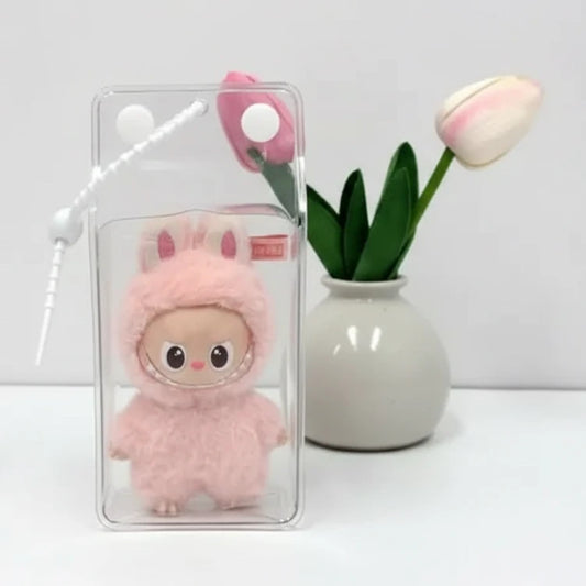 Étui Labubu transparent montrant une poupée avec un costume de lapin, décoré avec des livres et une fleur.