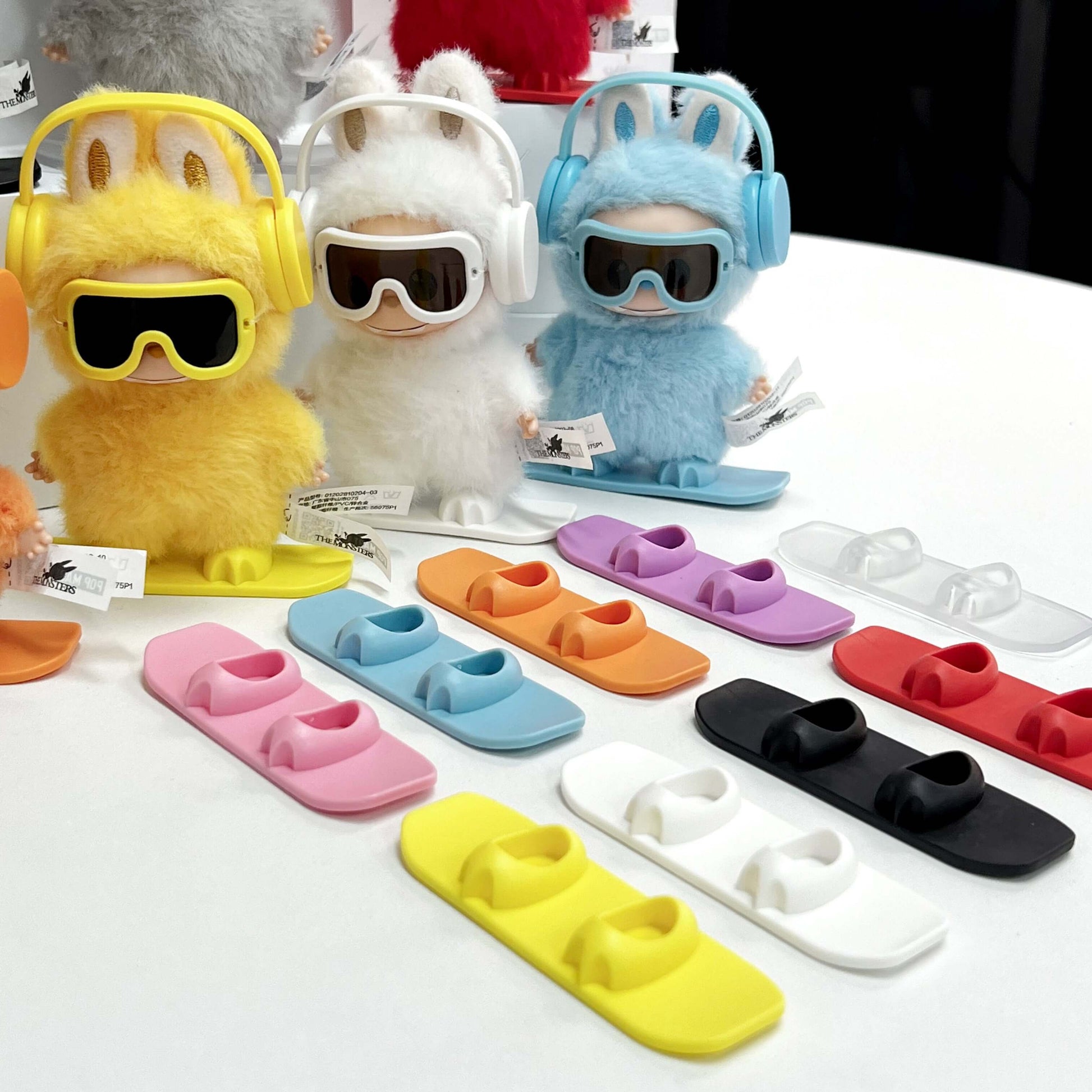 Équipement Snowboard pour Labubu - planche, écouteurs et lunettes sur des figurines colorées.