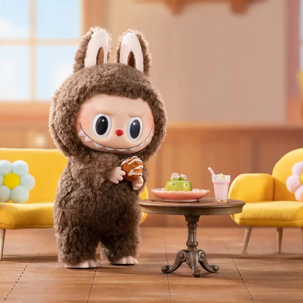Labubu en costume de lapin avec un biscuit dans une pièce lumineuse, entouré de fauteuils jaunes et de douceurs.