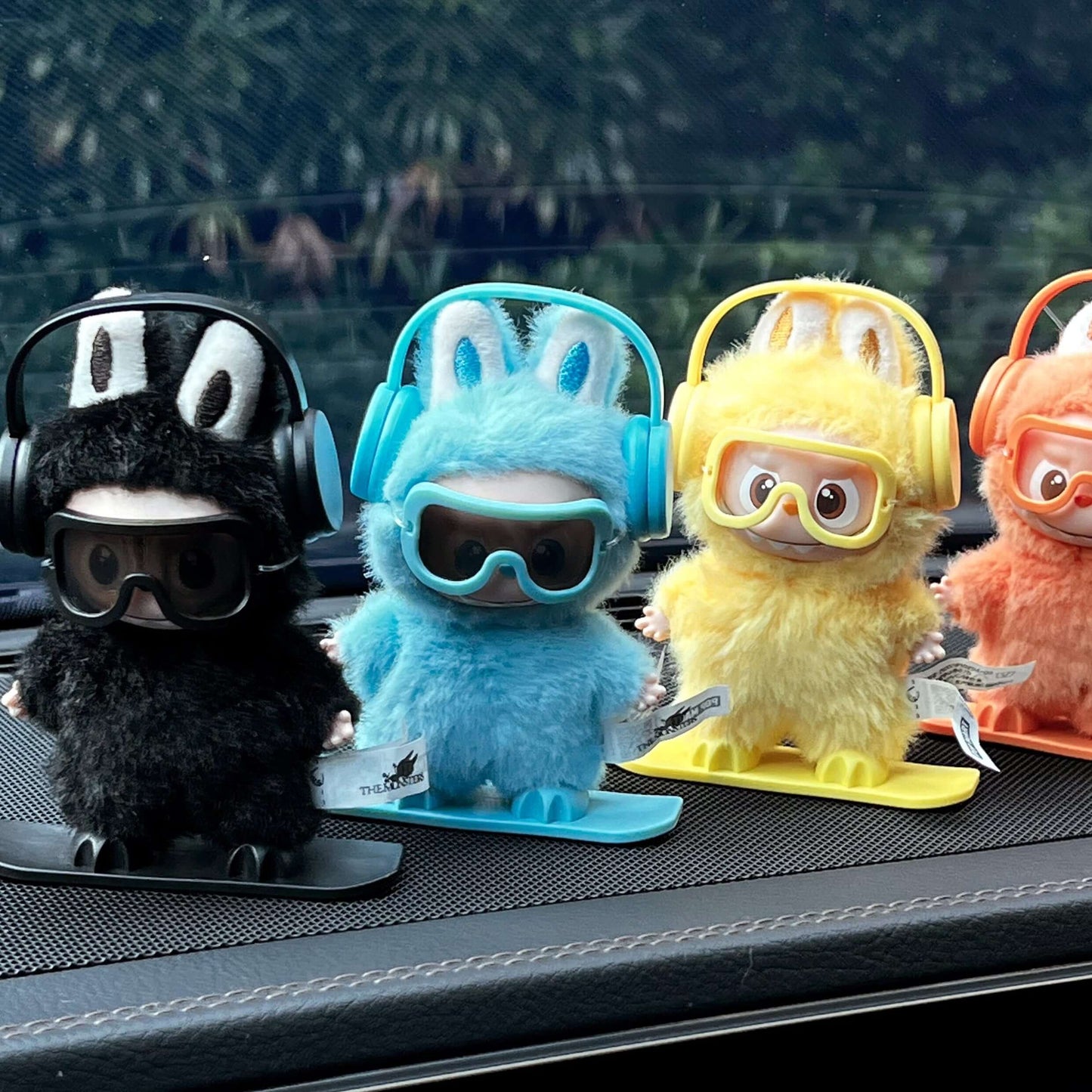 Équipement Snowboard pour Labubu - Figurines en peluche sur des planches de snowboard, portant des écouteurs et lunettes.