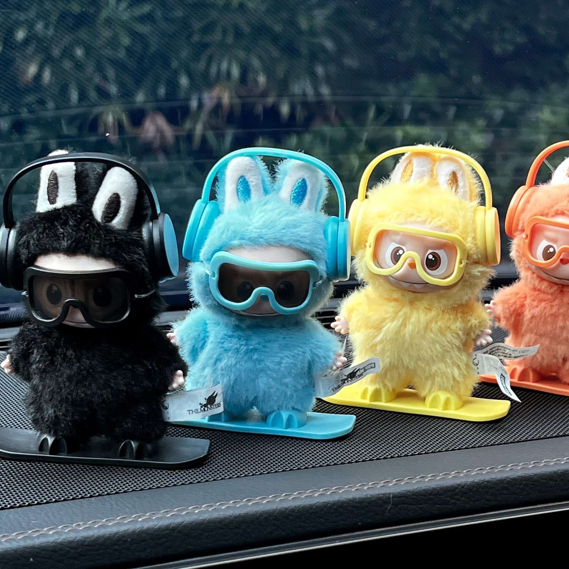 Équipement Snowboard pour Labubu - Figurines en peluche sur des planches de snowboard, portant des écouteurs et lunettes.