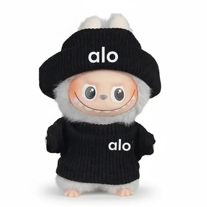 Doll wearing a black knitted sweater and hat with 'alo' logo, featuring cute animal-like features.
