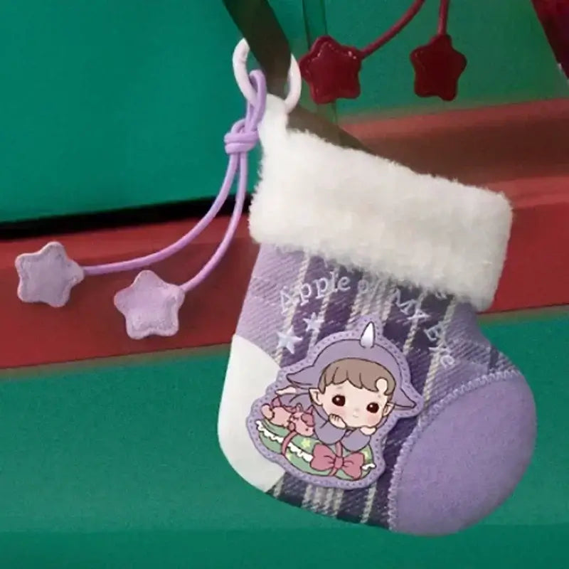 Chaussette Labubu Apple Of My Eye avec illustration mignonne sur une cheminée décorée de Noël.