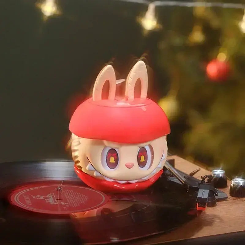 Labubu ❄️ Figure de collection de la série "Apple Of My Eye" sur un tourne-disque avec derrière un décor festif.