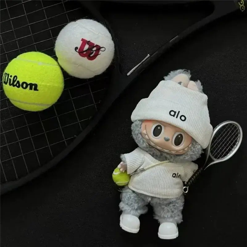 Tenue Labubu tennis avec raquette, tennis en peluche et balles de tennis Wilson sur un fond noir.