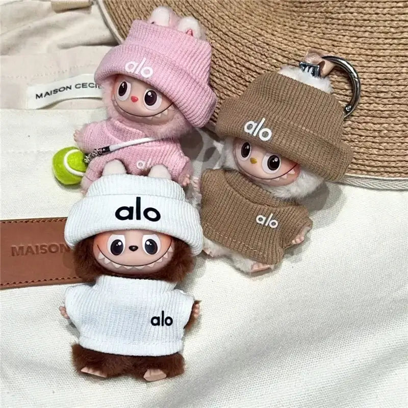 Trois figurines mignonnes portant des vêtements de la marque 'alo' sur fond neutre.