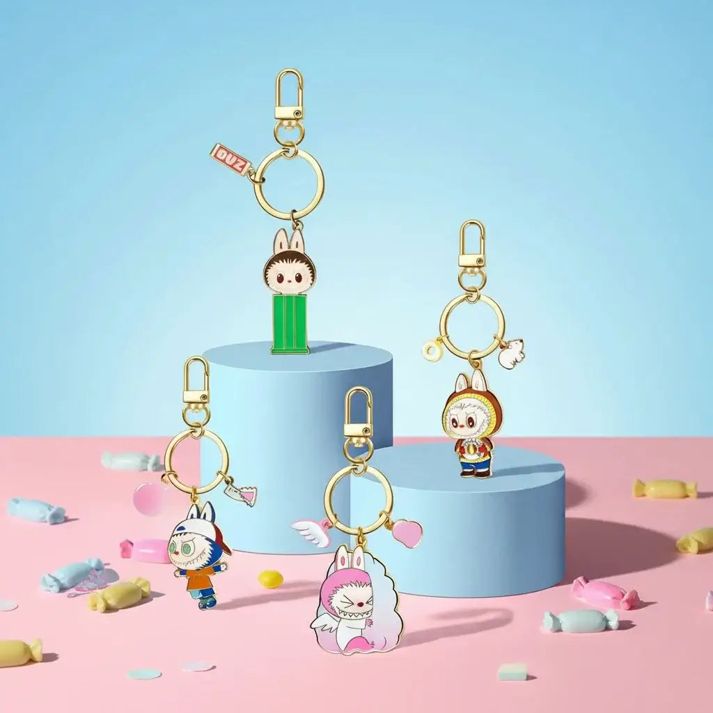 Labubu Porte-Clefs Bonbons - porte-clés colorés en forme de personnages sur des podiums avec des bonbons en arrière-plan.
